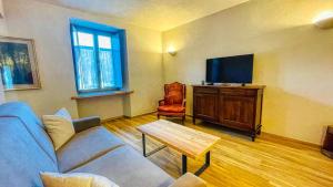 un salon avec un canapé bleu et une télévision dans l'établissement Casa Pozzallo Giulietta - Affitti Brevi Italia, à Oulx