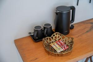 une table avec une cafetière et un panier de bonbons dans l'établissement Uncle Toy, à Ban Riang 3 autres photos