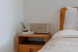 une table de chevet avec un lit et une télévision dessus dans l'établissement Uncle Toy, à Ban Riang