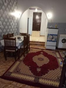 een eetkamer met een tafel en een tapijt op de vloer bij Nubian house in Jazīrat Salūjah