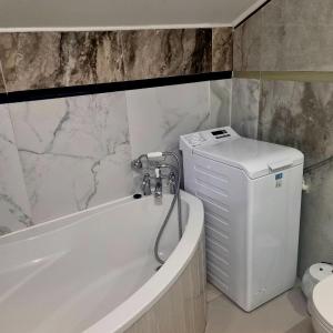 a bathroom with a tub and a toilet and a sink at Dom Kopernica 5 in Chełm