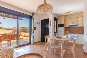 a kitchen and dining room with a table and chairs at Alma Ventura House - Majanicho in Majanicho