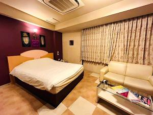 a bedroom with a bed and a chair and a table at ホテルクレアトゥール安城 in Wada +13 photos