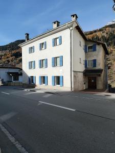 a large white building on the side of a road at B&B Berninapass Poschiavo Panorama in Poschiavo