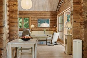 a living room with wooden walls and a table and chairs at Nordic Log Cabin With Views Over The Fields in Hals