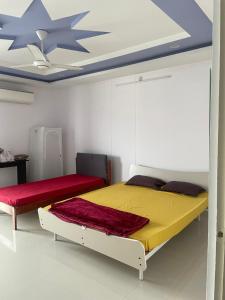 a bedroom with two beds and a ceiling at Elysium Inn in Hyderabad