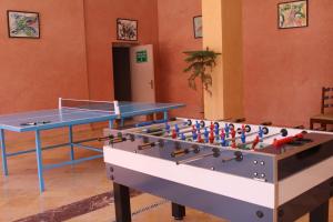 a ping pong table in a room with a table and a table at Hotel Idou Tiznit in Tiznit