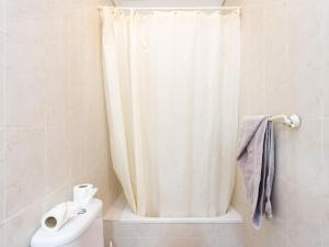 a bathroom with a shower curtain and a toilet at Live Salinas 3 in Caleta de Interián