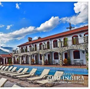a large building with lounge chairs next to a swimming pool at Complex Chilingira in Osikovo +14 photos