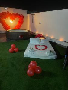 a room with a bed with red balloons on the grass at La Belle Escale in Pikine