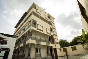 a tall white building with a lot of windows at Kesar Villa By DSR Group in Bedla +5 photos