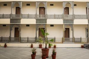 a building with a courtyard with potted plants at Kesar Villa By DSR Group in Bedla