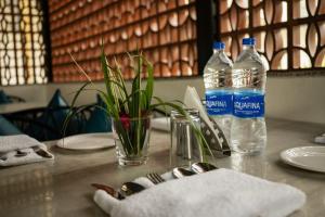 a table with two bottles of water on it at Kesar Villa By DSR Group in Bedla
