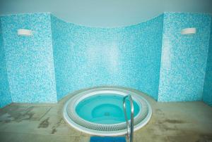 a blue tiled bathroom with a blue and white tub at Azoris Faial Garden – Resort Hotel in Horta