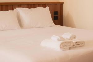two towels on a bed with white sheets at The Alluna Motel, an Ascend Collection Hotel in Armidale