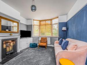 un salon avec un canapé et une cheminée dans l'établissement Charming Family Home with Parking Pass The Keys, à Chichester