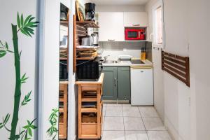 Una cocina con gabinetes verdes y un refrigerador blanco. en Deluxe Appartement, Charmant, au cœur du centre-ville, NICE CENTRE, en Niza