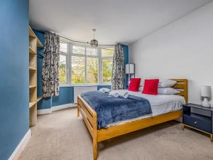 une chambre avec un lit avec des oreillers rouges dans l'établissement Charming Family Home with Parking Pass The Keys, à Chichester