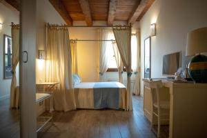 a bedroom with a bed and a desk and a window at Inghirios Wellness Country Resort in Santa Maria la Palma +48 photos