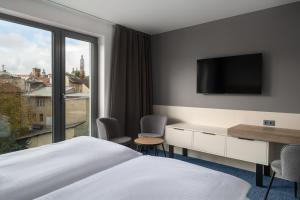 クトナー・ホラにあるHotel U Kataのベッドと大きな窓があるホテルの部屋