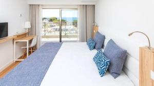 a bedroom with a large bed with blue pillows at Alfagar Prestige in Albufeira +28 photos
