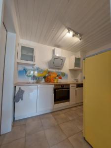 Una pequeña cocina con gabinetes blancos y un fregadero. en Nussperle, en NuÃŸbaum 2 fotos más