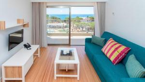 a living room with a blue couch and a table at Alfagar Prestige in Albufeira