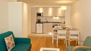 a living room with a kitchen and a table and chairs at Alfagar Prestige in Albufeira