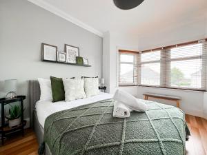 a bedroom with a bed with a green blanket at Ty-Fry House, by Solace Stays in Cardiff