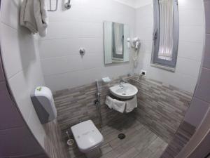 a small bathroom with a sink and a toilet at Hotel Runa in Mugnano di Napoli