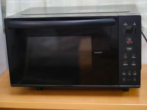 Un horno microondas negro sobre una mesa. en wanderers Inn, en Tanabe