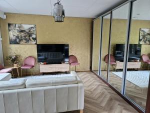 a living room with a white couch and a flat screen tv at Golden apartment- parking, wifi and sauna in Raisio