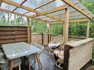 a wooden pergola with a table and chairs on a deck at Golden apartment- parking, wifi and sauna in Raisio
