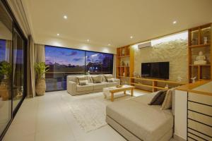 a large living room with a couch and a tv at Villa Grazia Luxury Retreat Canggu in Canggu