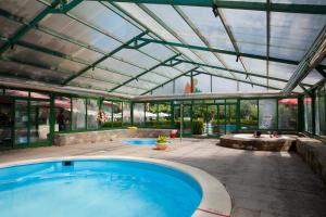 a swimming pool in a glass house with a hot tub at Bungalows Peña Montañesa in Aínsa