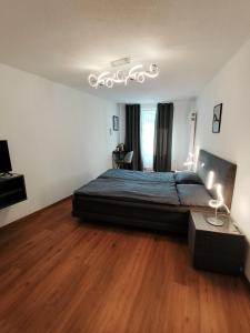 a bedroom with a bed and a chandelier at B&B Berninapass Poschiavo Panorama in Poschiavo