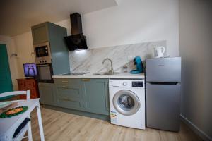 a kitchen with a washing machine and a refrigerator at Studio tout Équipé in Cambrai