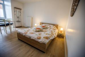 a bedroom with a bed and a table with two lamps at Studio tout Équipé in Cambrai