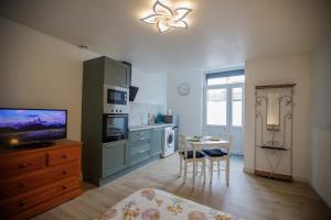 a kitchen with a television and a table with a chair at Studio tout Équipé in Cambrai
