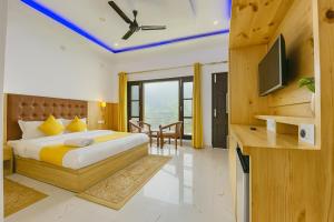 um quarto com uma cama e uma televisão em um cômodo em Hotel The SSB - ! luxury balcony rooms ! mountain view ! rooftop cafe ! big parking ! property of the year ! em Mussoorie