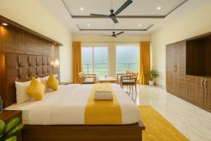 um quarto com uma cama grande com travesseiros amarelos em Hotel The SSB - ! luxury balcony rooms ! mountain view ! rooftop cafe ! big parking ! property of the year ! em Mussoorie