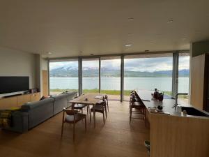 een woonkamer met een bank en een tafel met stoelen bij Saeluheimur - Oceanside Sanctuary in Akureyri