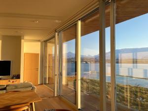 een woonkamer met glazen schuifdeuren en uitzicht bij Saeluheimur - Oceanside Sanctuary in Akureyri