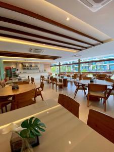 un restaurant avec des tables et des chaises et une cafétéria dans l'établissement Porto de galinha Muro alto Mana Beach Experience 320B, à Porto de Galinhas