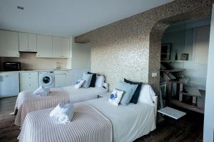 two beds in a small room with a kitchen at Moonkey - Casa El Cabo in Balcon del Mar +21 photos