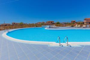 a large swimming pool with blue water in a resort at Alma Ventura House - Majanicho in Majanicho