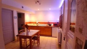 Grand Studio Côté Jardin في Saint-Sernin: مطبخ مع طاولة خشبية وطاولة وطاولة طعام +39 صورة