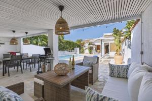 Una sala de estar al aire libre con mesa y sillas. en Casa del Limonero, en El Tosalet