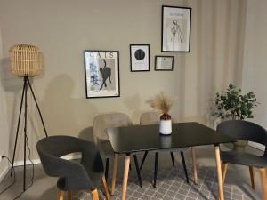 une salle à manger avec une table et des chaises noires dans l'établissement Stylische Wohnung mit Garten im Zentrum, à Neumünster