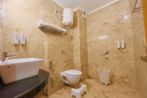 a bathroom with a toilet and a sink and a shower at The Kempty Osasis - A Boutique Resort With Scenic Mountain View in Mussoorie in Mussoorie +25 photos